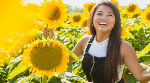 person smiling in sunflowers