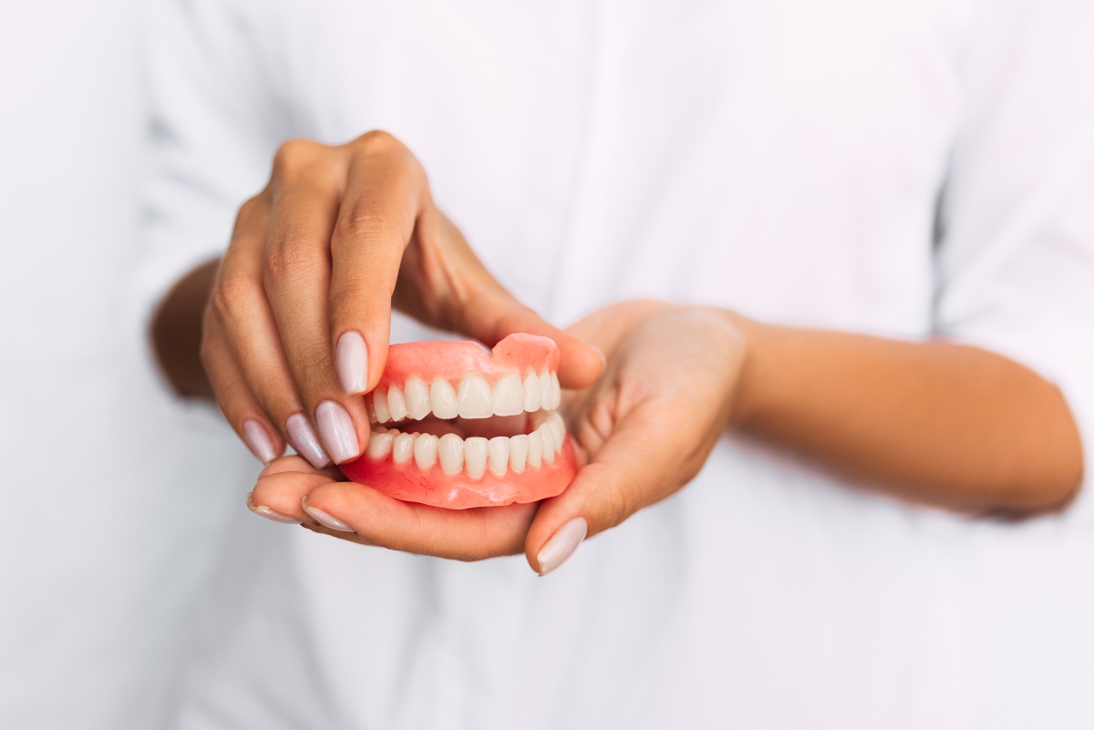 dentist is holding dentures in his hands