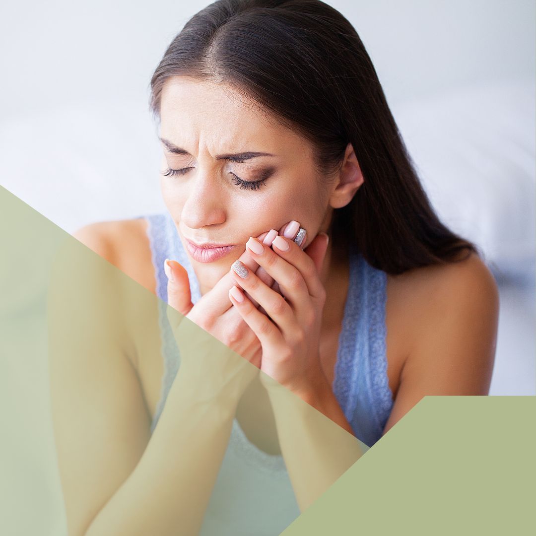 woman holding jaw in pain