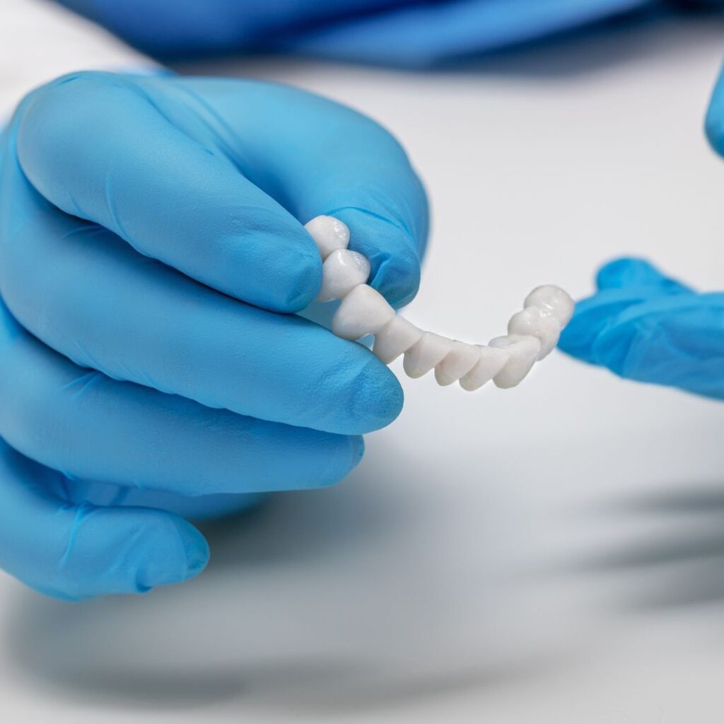 dentist holding dental bridge