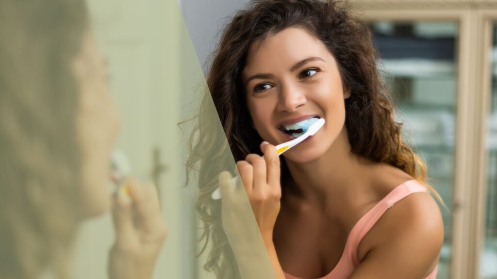 smiling woman brushing teeth