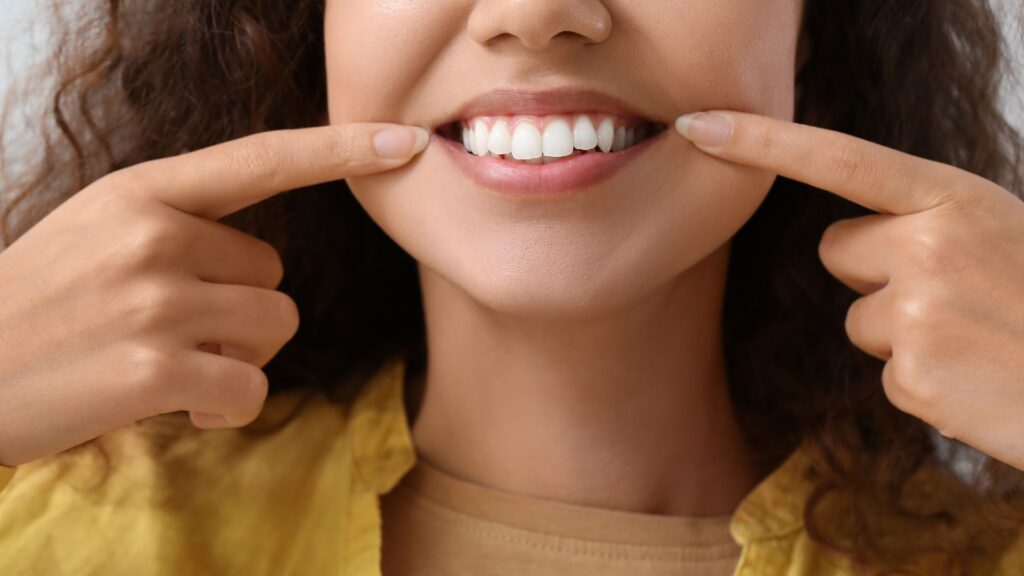 woman pointing at her healthy smile