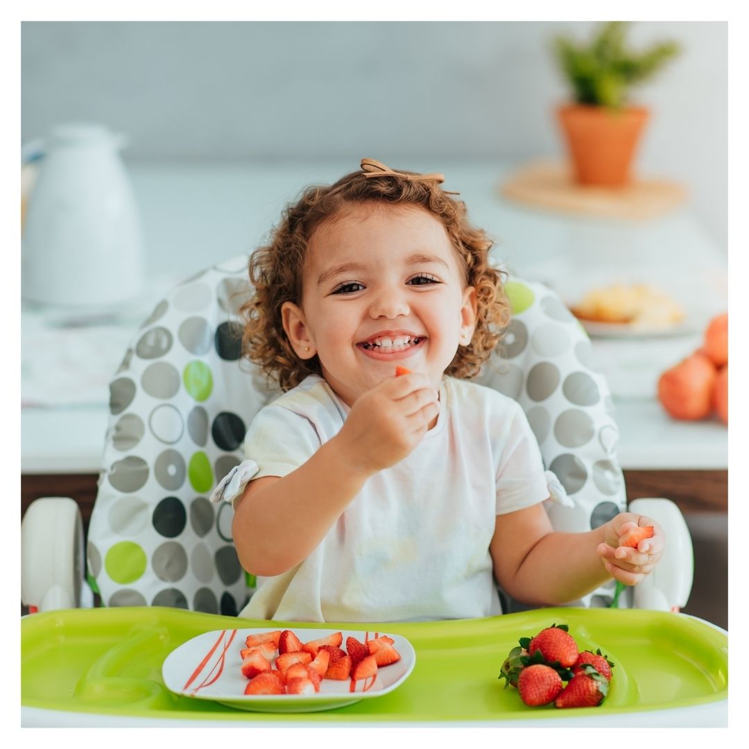 little girl eating a healthy snack happily