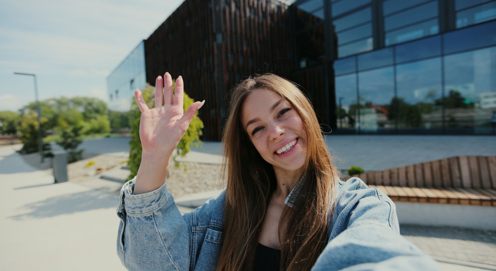 woman smiles and waves at camera
